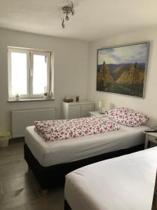 a bedroom with two beds and a painting on the wall at Gästehaus Glock in Marbach am Neckar