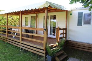 una terraza de madera con toldo en una casa en Agriturismo Al-Bor, en Lazise