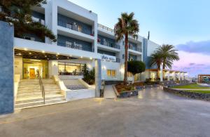 un grand bâtiment avec des palmiers devant lui dans l'établissement Astir Beach Hotel, à Gouves