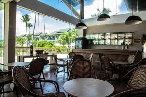 ein Restaurant mit Tischen und Stühlen und eine Bar in der Unterkunft Beach Class Muro Alto Condomínio Resort By New Time in Porto De Galinhas