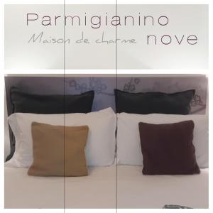 a bed with four pillows and a sign that reads pamperinama at Parmigianino Nove in Parma