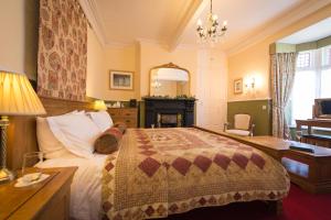 a bedroom with a bed and a desk and a fireplace at Victoria House Room Only Accommodation in Caernarfon