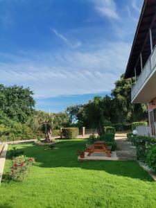 a garden with a picnic table and a lawn at Ilias Apartments Dassia By Hotelius in Dassia