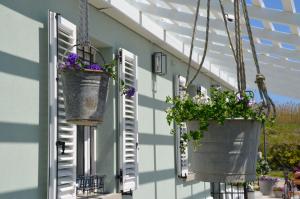 a house with flowerpots hanging from a window at B&B Le Col-vert in Lido di Dante