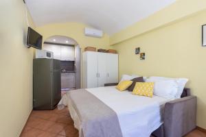 a bedroom with a large bed and a refrigerator at Nizza Studio Apartments by Wonderful Italy in Turin