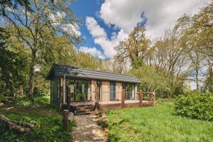 a small wooden cabin in a field with trees at Woodland Cabin in Upton upon Severn