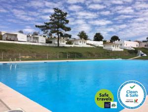 Una piscina azul con casas al fondo. en Campimeco by Campigir, en Alfarim