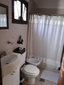 Baño blanco con aseo y lavamanos en La Tranquera Alquiler Temporario en Cafayate
