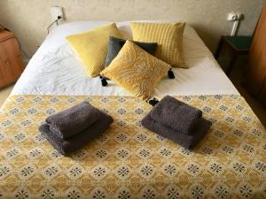 a bed with pillows on top of it at La Maison du Bonheur - Grande maison de vacances classée 4 étoiles in Le Boupère