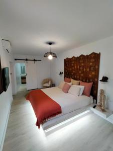 a bedroom with a large bed with a red blanket at Villa Aura in La Sorrueda