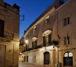 un vieux bâtiment dans une rue la nuit dans l'établissement Palazzo Rollo, à Lecce