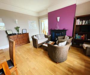 sala de estar con sillas, chimenea y pared púrpura en The Brookfield, en Braunton
