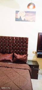 Bett mit einem Kopfteil aus Leder in einem Schlafzimmer in der Unterkunft My place agata Hostel in Kairo