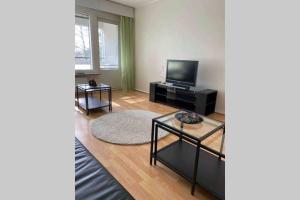 a living room with a television and a table at Olivia apartment Porvoo in Porvoo