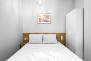 sypialnia z łóżkiem z białą pościelą w obiekcie Nemea Apartments, The Luxury Suites w Salonikach