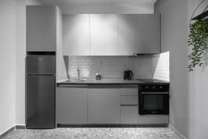kuchnia z białymi szafkami, zlewem i lodówką w obiekcie Nemea Apartments, The Luxury Suites w Salonikach +14 zdjęć