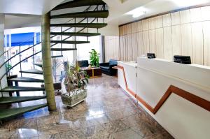 a lobby with a spiral staircase in a building at Hotel Ipanema Inn Higienópolis in Sao Paulo