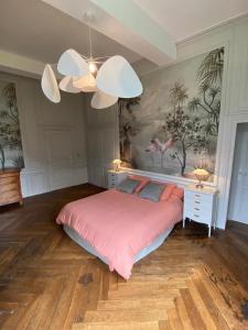 a bedroom with a large bed with a pink blanket at Domaine des Longrais in Saint-Thurial