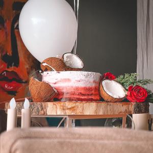 a table topped with a cake and a balloon at Sharz Hotel in Buraydah