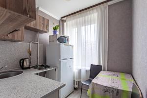 una pequeña cocina con nevera blanca y ventana en Standard Brusnika Apartment on Eniseyskaya, en Moscú