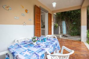 stół z niebiesko-białym blatem na patio w obiekcie Appartamento Marea by HelloElba w mieście Fetovaia