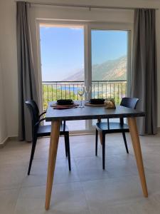 a dining room table with two chairs and a large window at La Moda Aparts in Kas