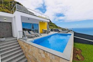 une maison avec une piscine et l'océan dans l'établissement Villa Golden Charm, à Tábua
