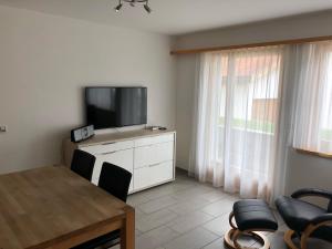 a living room with a television and a table and chairs at Chasa Mundin in Scuol