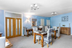 a dining room with blue walls and tables and chairs at Mount Edgcombe in Torquay