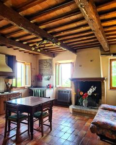 uma sala de estar com uma mesa e uma lareira em La Cascina di Muttley em Doglio