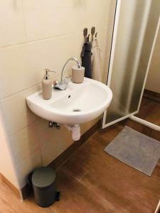ein weißes Waschbecken im Bad mit Spiegel in der Unterkunft Szépasszonyvölgyi Apartman in Eger