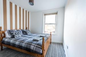 Schlafzimmer mit einem Bett und einem Fenster in der Unterkunft Hepburn House 4 Bedroom Property - Stayseekers in Salisbury