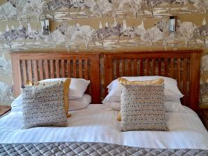 a bedroom with a bed with white sheets and pillows at Laurel Cottage in Windermere