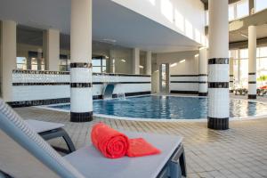 uma piscina do hotel com uma toalha vermelha numa cadeira em Luna Hotel de Tbua na Tbua
