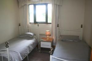 Tempat tidur dalam kamar di Barn Cottage - Farm Park Stay with Hot Tub