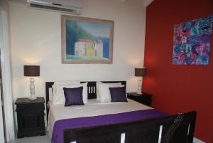 a bedroom with a bed and a painting on the wall at Brisas Studio Apartments in Palm-Eagle Beach