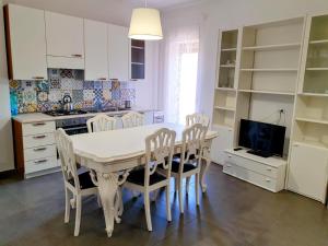 a kitchen with a white table and chairs and a tv at Le Sorelle Apartment in Agrigento