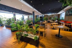 a restaurant with tables and potted plants at LD Sevilla in Guillena