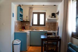 a kitchen with a sink and a table in a room at Arhondiko in Sougia