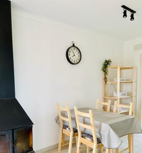 l'Era de Can Viñas في Albóns: غرفة طعام مع طاولة وساعة على الحائط