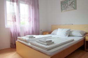 una camera da letto con un letto con asciugamani sopra di Apartmani Zvirac a Soko Banja