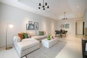 a living room with a couch and a table at Spacious 2BR in Jumeirah 3, 10 Mins From The Beach - NOX Holiday Homes in Dubai