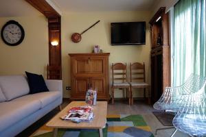 a living room with a couch and a table at COTTAGE ON THE CANAL in Kortrijk