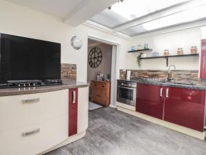 a kitchen with a flat screen tv on the counter at Poppy Cottage in Deal