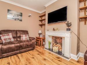 a living room with a couch and a fireplace at Poppy Cottage in Deal