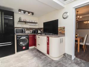 a kitchen with a washing machine and a washer and dryer at Poppy Cottage in Deal +15 photos