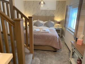 a bedroom with a bed with two towels on it at Bakers Cottage in Ironbridge