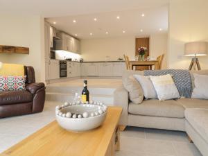 a living room with a couch and a table with a bottle of wine at Hen Dy Bryn Mawndy in Corwen