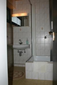 a bathroom with a sink and a bath tub at Pension Altenbeck & Ferienwohnung in Winterberg