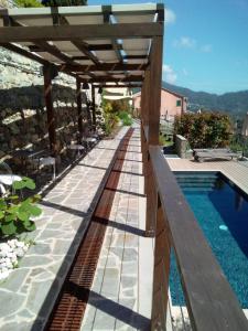 a patio with a wooden pergola and a swimming pool at L'Antico Borgo B&B in Levanto